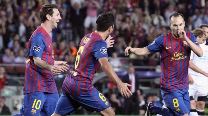 Andrés Iniesta (r.) lässt sich von Lionel Messi (l.) und Xavi feiern.