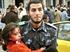 Ein palästinensischer Polizist mit einem Mädchen nach den israelischen Angriffen vom Samstag.